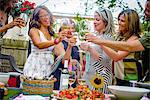 Group of people at garden party, holding wine glasses, making a toast