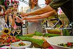 Group of people at garden party, holding wine glasses, making a toast, mid section