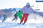 Male and female skiers skiing on snow covered ski slope, Aspen, Colorado, USA