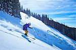 Man skiing down steep snow covered mountainside, Aspen, Colorado, USA