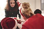 Young woman handing out popcorn at christmas party