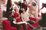 Young man eating dangled doughnut at christmas party