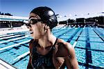 Swimmer in swimming cap and goggles catching breath by pool