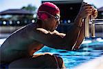 Swimmer hanging onto pool ladder