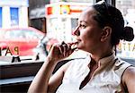 Businesswoman with hand on chin in coffee bar