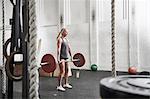Woman lifting barbell in cross training gym