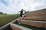 Young man exercising, running outdoors, leaping up steps, South Point Park, Miami Beach, Florida, USA