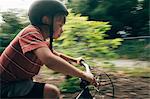 Young boy riding bicycle outdoors