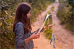 Teenage girl gazing at kite on dirt track