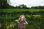 Portrait of girl with wavy blond hair laughing in field