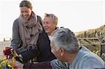 Laughing senior couples drinking champagne on sunset beach