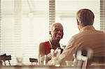 Senior couple drinking wine, dining at restaurant table