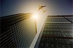 Airplane flying over highrise buildings, travel concept