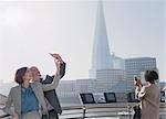 Business couple taking selfie with camera phone, London, UK