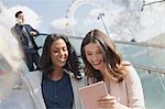 Smiling businesswomen using digital tablet outdoors