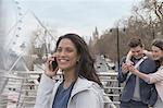 Smiling woman talking on cell phone on urban bridge, London, UK