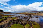 Rocky shoreline of river flowing into the sea bay on the Isle of Skye in Scotland, United Kingdom