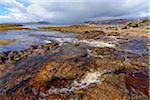 Rocky shoreline of a river flowing into the sea bay on the Isle of Skye in Scotland, United Kingdom