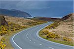 Winding country road with an overcast sky in springtime in the Isle of Skye, Scotland, United Kingdom