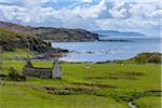 Remains of a stone house in grassy field along the coast on the Isle of Skye in Scotland, United Kingdom