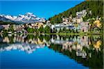 The resort town of St Moritz reflected in Lake St Moritz in the Engadin valley on a sunny day with the Swiss Alps in the background, Switzerland