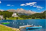 Rowboats moored along the shoreline of Lake St Moritz with the Waldhaus Hotel in the background on a sunny day at St Moritz, Switzerland