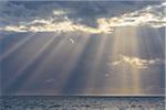 Crepuscular sunrays shining through the clouds over the North Sea, United Kingdom