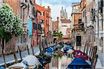 View of boats moored along a canal lined with historical buildings in Venice, Italy
