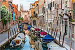 View of boats moored along a canal lined with historical buildings in Venice, Italy