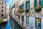 Close-up of buildings with windowboxes lining a canal in early morning in Venice, Italy