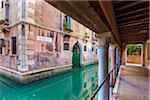 Walkway under a bridge crossing a canal in Venice, Italy