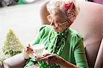 Happy quirky vintage mature woman holding teacup and saucer in tea rooms