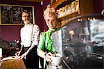 Quirky vintage couple working behind counter in tea rooms