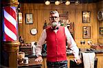 Portrait of quirky senior man in traditional old english barber shop