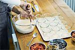 Chefs preparing berry desserts, mixing cream, mid section