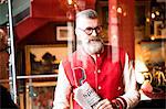 Quirky man with sports newspapers in bar and restaurant, Bournemouth, England