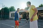 Friends on basketball court doing fist bump