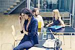 Businesswoman sitting contemplating on boardroom table