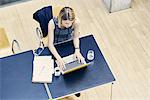 High angle view of young businesswoman typing on laptop at office desk