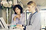 Two businesswomen looking at laptop in stylish office