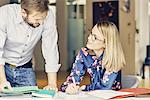 Businesswoman talking to male colleague at desk