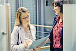 Businesswomen having meeting in corridor of office