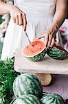 Woman cutting watermelon on cutting board