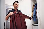 Man choosing shirt from closet