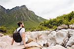 Man sitting on rocks looking away, Accursed mountains, Theth, Shkoder, Albania, Europe