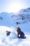 Siblings and snowman, Hintertux, Tirol, Austria