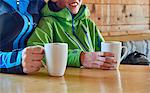 Father and son taking coffee break in log cabin, Hintertux, Tirol, Austria