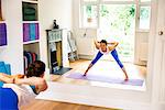 Mirror image of woman bending forward in yoga position