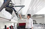 Young female sales manager pointing at chairs in office furniture store