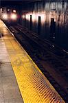 Subway train with headlights arriving at subway platform, Times Square, New York, USA